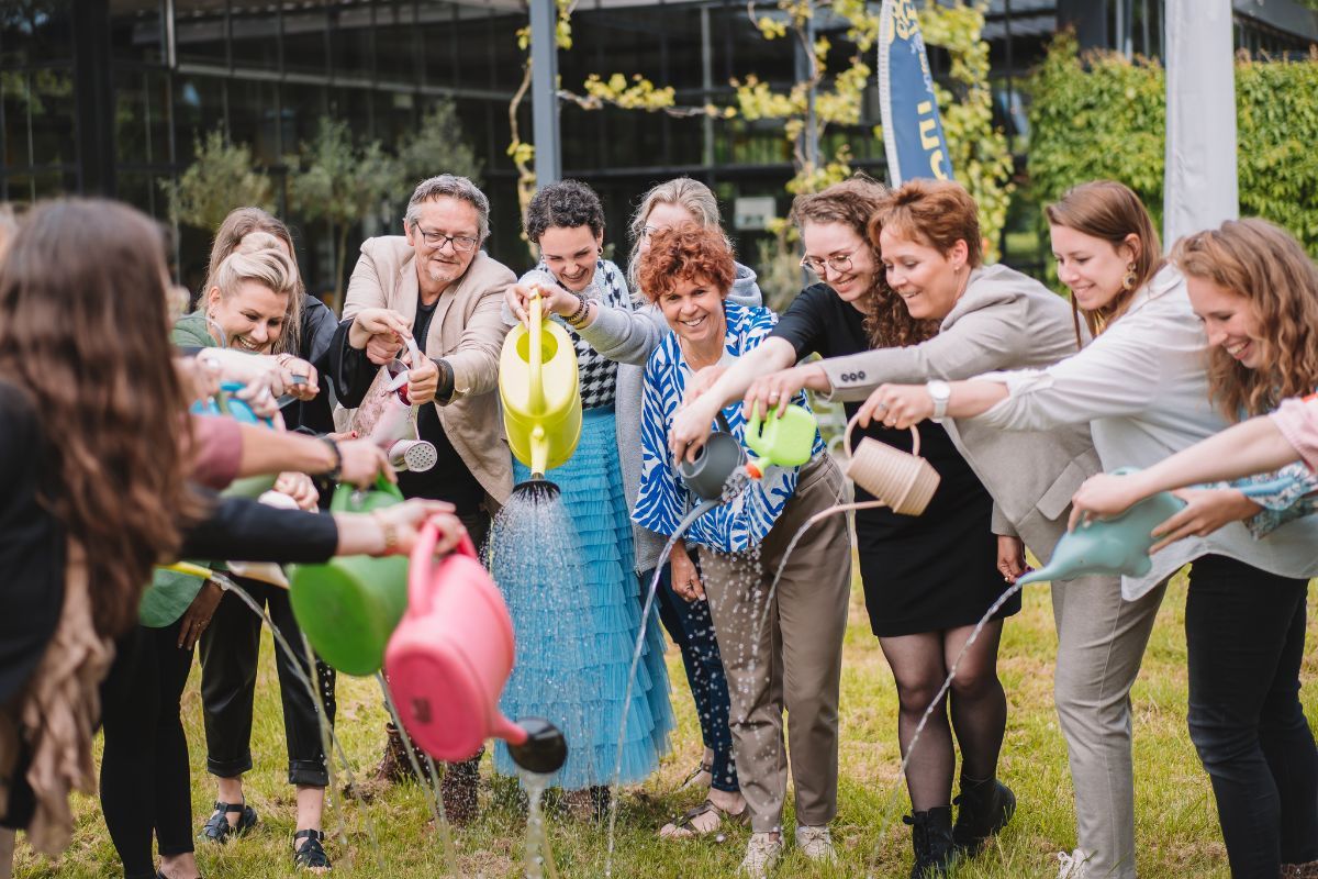 Leven Lang Ontwikkelen - mensen gieten water vanuit gieters op het gras