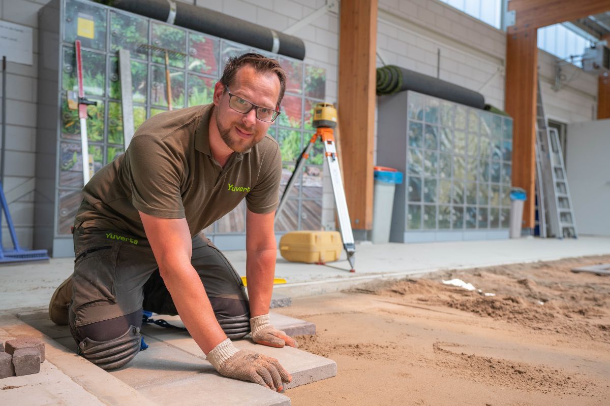 Opleiding groenvoorziening hovenier - man legt stenen op zand